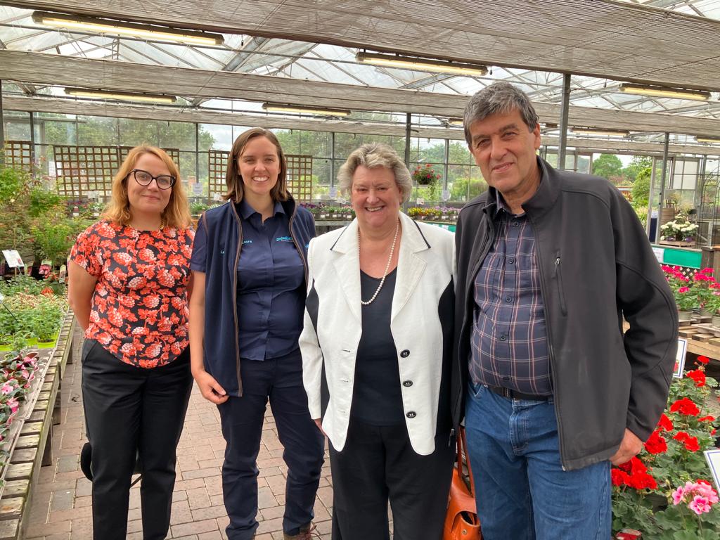 L-R Jennifer Pheasey from the HTA, Laura Jackson, Heather Wheeler MP and John Jackson standing in a garden centre surrounded by plants